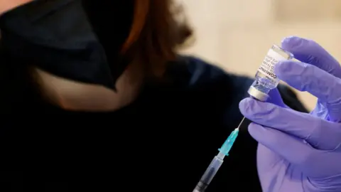 Reuters Woman prepares dose of Covid vaccine