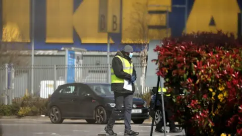 Getty Images NHS workers wait to be tested for Covid-19 at a drive-in facility set up in IKEA car park in Wembley, north-west London on 31 March, 2020