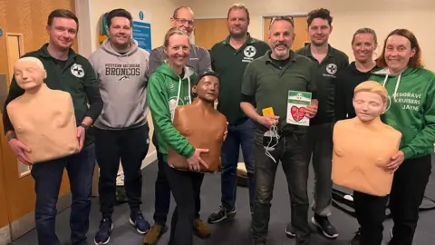 Kesgrave Kruisers Volunteers from Suffolk Ambulance Rescue Service with members of Kesgrave Kruisers and James Thurkettle, holding equipment used for the CPR training session