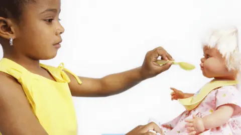 Thinkstock Girl feeding a doll