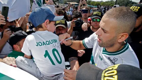 Albari Rosa/AFP Forward Islam Slimani, Algeria's all-time leading scorer, signs a jersey as he is welcomed by supporters of his new football team Coritiba.