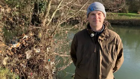 Charlie Halliday standing next to the River Avon