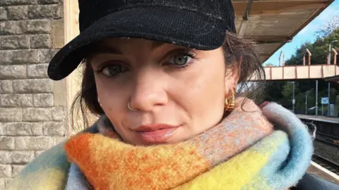 Hannah Ryan Hannah Ryan in a black cap and multi-coloured scarf