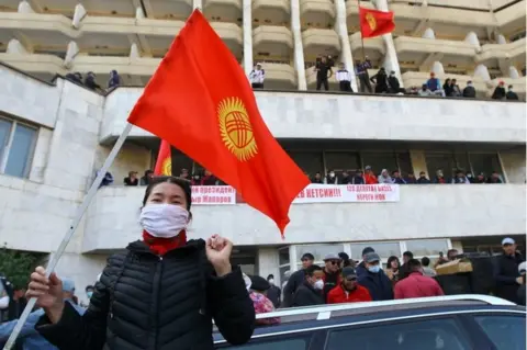 Reuters A woman holds the national flag as supporters of Kyrgyzstan"s Prime Minister Sadyr Japarov attend a rally in Bishkek, Kyrgyzstan October 15, 2020.