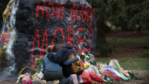 Getty Images People leave flowers at a makeshift memorial at Michigan State University