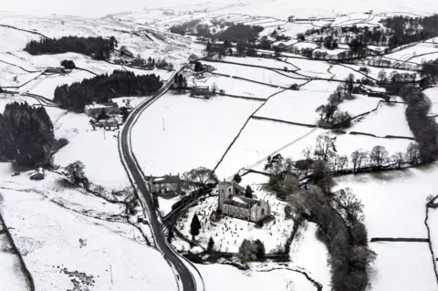 PA Media Snow covered fields and hills surround St Mary The Virgin Church in the Arkengarthdale, North Yorkshire, amid freezing conditions in the aftermath of Storm Arwen