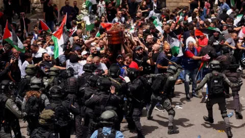 Reuters Israeli police kick and beat pallbearers at the funeral of Palestinian-American journalist Shireen Abu Aqla in occupied East Jerusalem (13 May 2022)