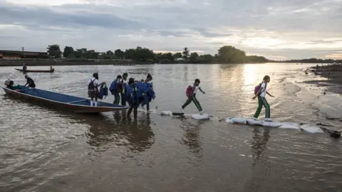 Glenna Gordon/Save the Children School kids and others disembark from small canoes