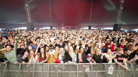 PA Media People watch Zuzu perform on stage at a music festival in Sefton Park in Liverpool as part of the national Events Research Programme (ERP)