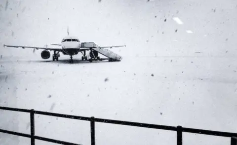 Reuters Heavy snow falls on the tarmac of the Glasgow Airport in Glasgow