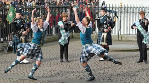 Yui Mok/PA Wire Highland dancers and musicians performing outside Westminster Abbey ahead of the service