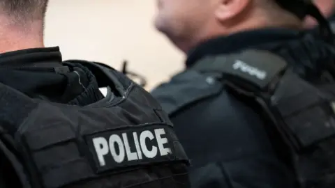 PA Media Photo of the back of two police officers