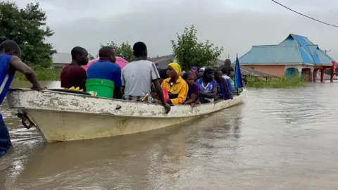 Eagan Salla /BBC People being rescued in a canoe in Rufiji district in Coastal region earlier this month