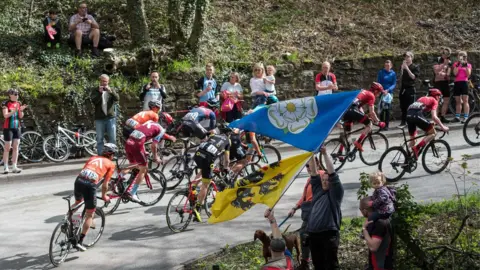 Getty Images A man waving a Yorkshire flag watches the 2018 Tour de Yorkshire