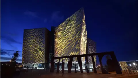 Getty Images The Titanic building and visitor centre is lit up in yellow for the Day of Reflection on 23 March 2021 in Belfast, United Kingdom.