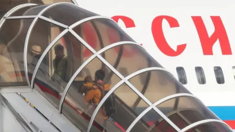 Reuters Former Russian embassy staff board a plane at Stansted airport