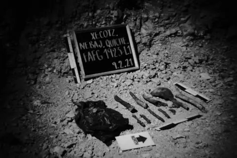 James Rodriguez Human remains are lined up along a blackboard which identifies the site where human remains were found. Xecotz, Nebaj, Quiche, Guatemala. February 9, 2021.