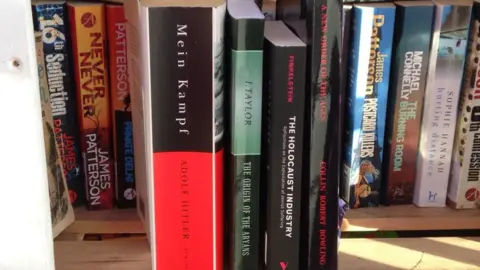 BBC Books in phone box. Titles include Mein Kampf by Adolf Hilter, The Origin of the Aryans by I Taylor, The Holocaust Industry by Finkelstein and A New Order of The Ages by Collin Robert Bowling