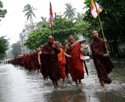 Getty Images Buddhist monks marching down a street in Myanmar's Yangon on 20 September 2007