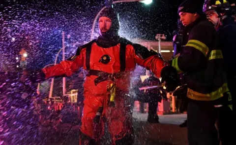 Reuters Rescue divers were hosed down with fresh water after emerging from the river