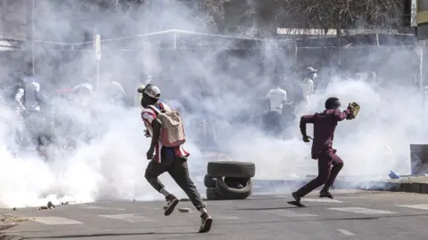 AFP Protestors run from teargas during clashes with police in Dakar on February 9, 2024.