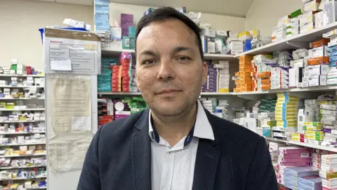 Andrew Turner/BBC Mansour Dadkha in a pharmacy