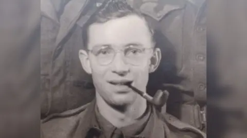Family photo Dennis Lanham as a young man in uniform smoking a pipe