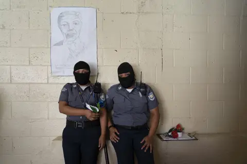 Tariq Zaidi Women prison guards, wearing balaclavas to protect their identities, stand in front of a portrait of Nelson Mandela at the Penal Center of Quezaltepeque, El Salvador. November 9, 2018.