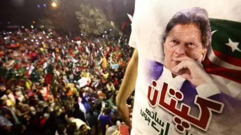 EPA A protester wears an Imran Khan supporter shirt at a rally in Karachi on Sunday night