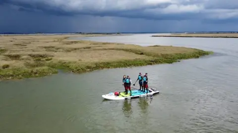 Barry Scott Oli Jordan, Andy Large, Jess Ashley and Matt Payne on the paddleboard