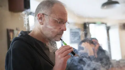 Science Photo Library Man vaping in a bar