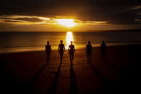 Anna Moffat Group of people in silhouette on a beach