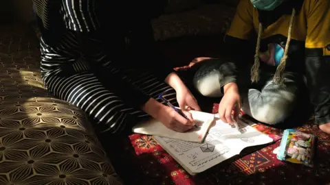 Reuters girl writes in a notebook