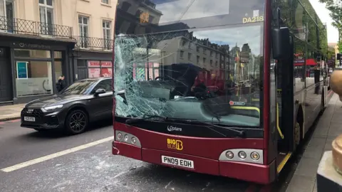 Photo showing smashed glass on a tour bus near the scene of the collision with a horse in London