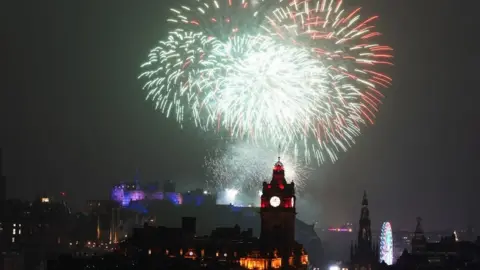 PA Media Fireworks explode over Edinburgh Castle during the street party for Hogmanay New Year celebrations in Edinburgh.