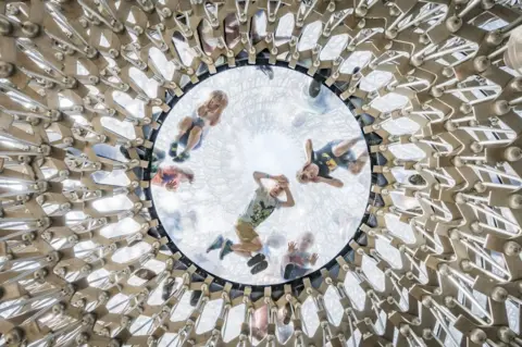 Omer Kanipak / APA18 Children looking down through a glass-domed ceiling