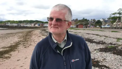 Professor John Parnell portrait on beach on Millport