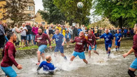 PA Media Bourton-on-the-Water football in the river