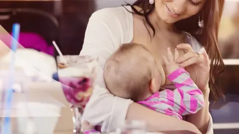 Halfpoint Woman breastfeeding in restaurant