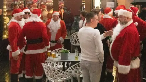 Getty Images Father Christmases outside a bar