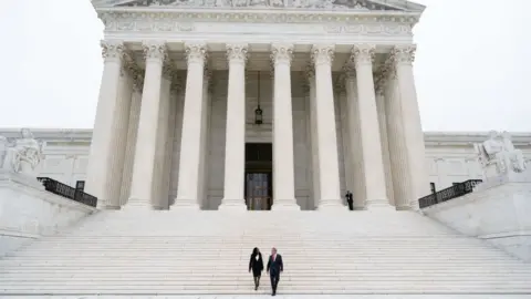 Getty Images US Supreme Court Justice Ketanji Brown Jackson and Chief Justice John Roberts walk down the steps of the US Supreme Court, immediately following the investiture ceremony of Justice Jackson in Washington, DC, September 30, 2022