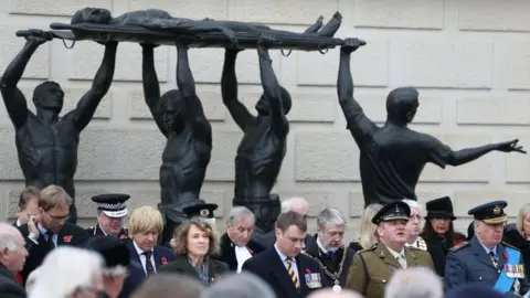 PA People observe a two minute silence during a service of Remembrance at the National Memorial Arboretum in Staffordshire