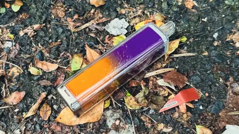 Getty Images A discarded orange and purple disposable vape lies on the ground