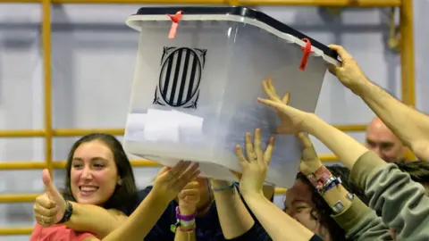 AFP People smiling hold aloft a ballot box, shut and sealed with anti-tamper ties, as they celebrate the end of polling day