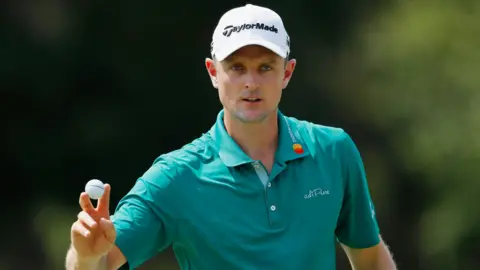 Justin Rose acknowledges the crowd by raising a golf ball between his fingers