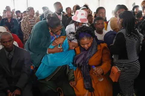 PHILL MAGAKOE/AFP Family members react during a procession of empty coffins at a symbolic mass memorial service in East London on 6 July 2022. In total, 21 young people, mostly teenagers, died in unclear circumstances at a township tavern last month