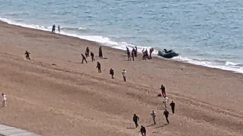 PA Media People arriving on the beach at Folkestone by boat