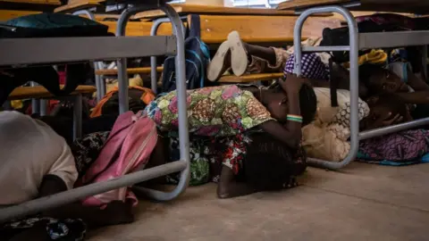 Getty Images Primary school children lie on the floor of their classroom during an emergency attack simulation in Dori on February 3, 2020