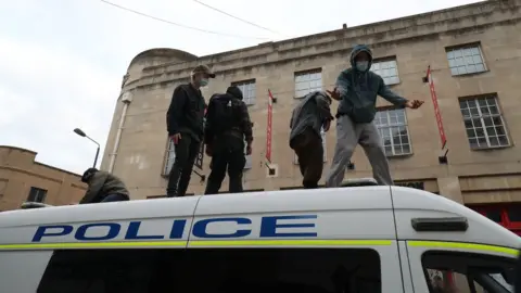 PA Media Protestors climbed on top of a police van