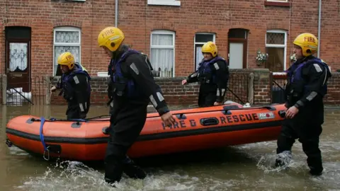 Getty Images Firefighters search homes in the flooded village of Treeton, near Rotherham